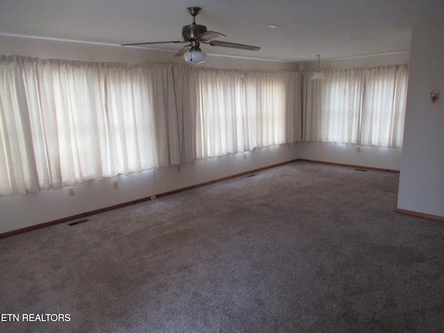 carpeted spare room featuring baseboards and visible vents