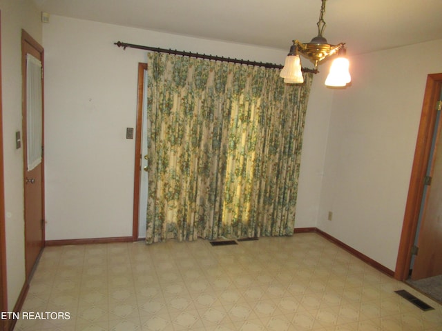 empty room featuring baseboards, visible vents, and light floors