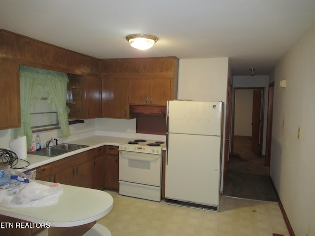 kitchen with under cabinet range hood, white appliances, a sink, light countertops, and light floors