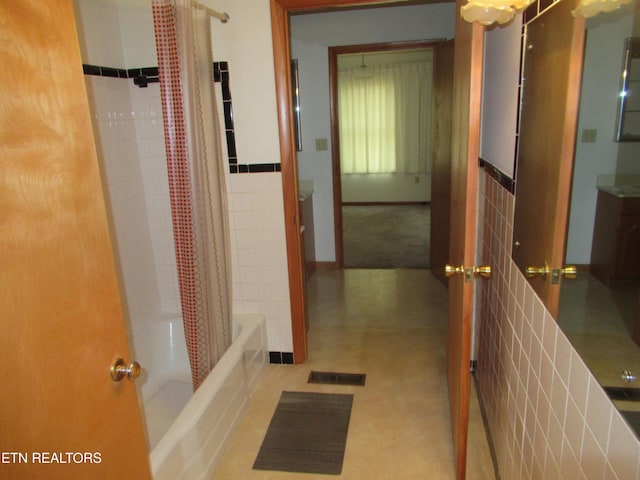 bathroom with visible vents, shower / bath combination with curtain, and tile walls