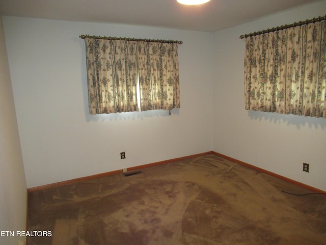 carpeted empty room with visible vents and baseboards