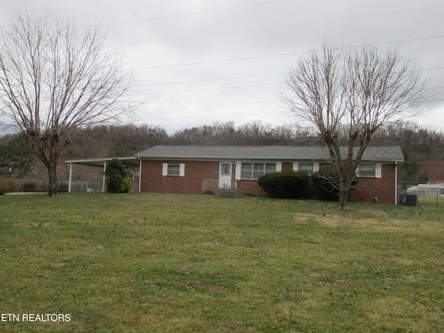 ranch-style home featuring brick siding, a carport, and a front yard