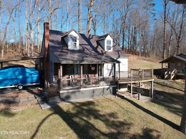 view of front of home featuring a front yard, covered porch, and a chimney