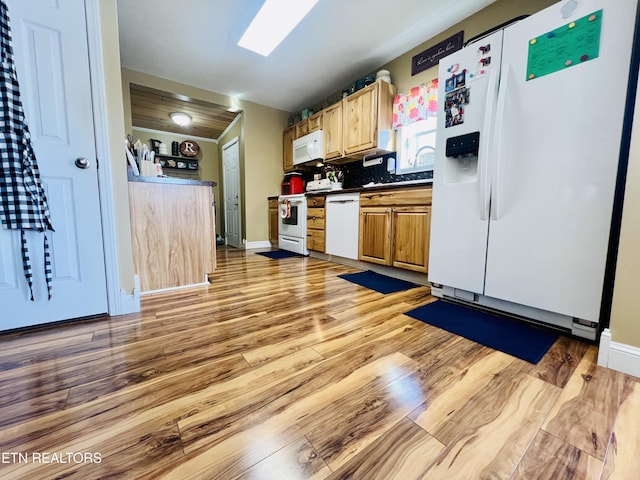 kitchen with white appliances, baseboards, light wood finished floors, dark countertops, and backsplash