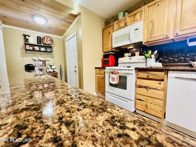 kitchen with dark stone counters, white appliances, and ornamental molding