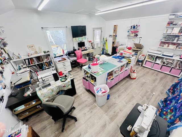 recreation room with lofted ceiling, attic access, and wood finished floors