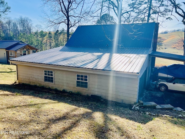 view of side of property featuring a carport and metal roof