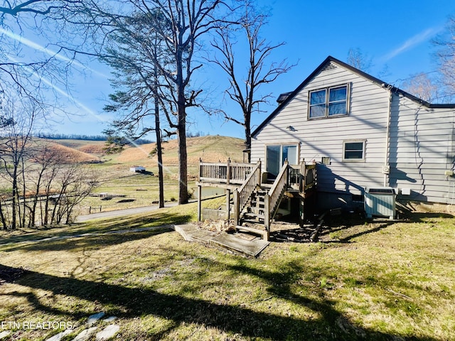 rear view of house featuring stairway, cooling unit, a yard, and a wooden deck