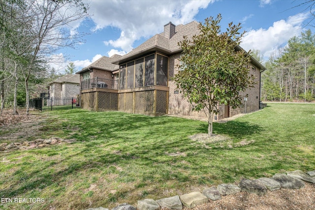 12 Inwood Dr, Fairfield Glade, TN 38558 - back of property featuring a sunroom, a yard, a shingled roof, brick siding, and a chimney
