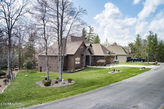 12 Inwood Dr, Fairfield Glade, TN 38558 - french country home featuring a front yard, stone siding, and driveway