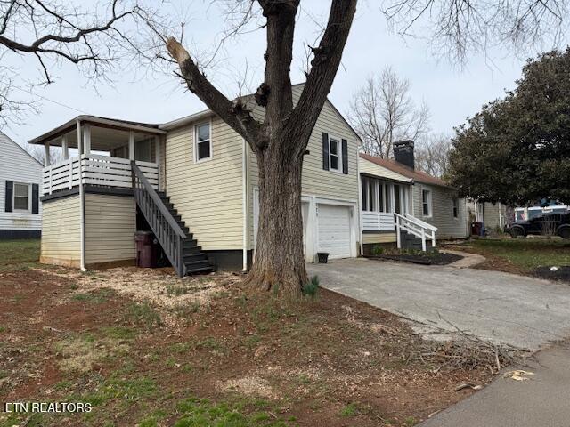 exterior space with concrete driveway, stairs, and a garage