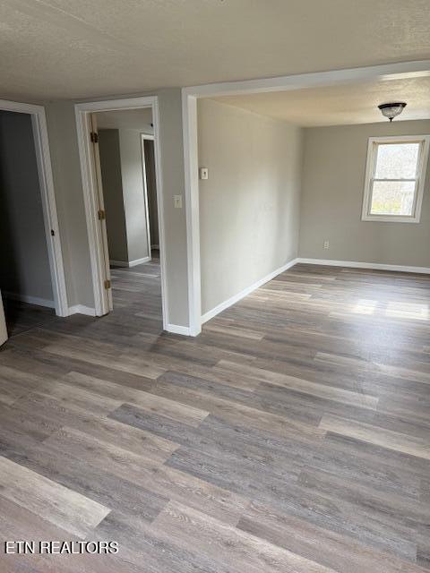 empty room featuring wood finished floors and baseboards