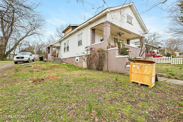 view of front of property featuring a front lawn, fence, and ceiling fan