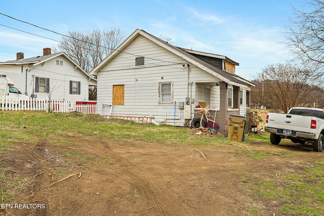 rear view of property featuring fence