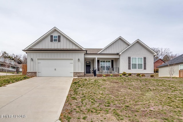 view of front of property featuring a porch, concrete driveway, a front lawn, a garage, and board and batten siding