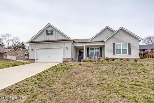 view of front of house with a front lawn, driveway, covered porch, board and batten siding, and a garage