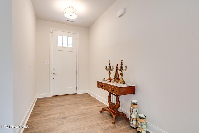 foyer with visible vents, baseboards, and light wood-type flooring