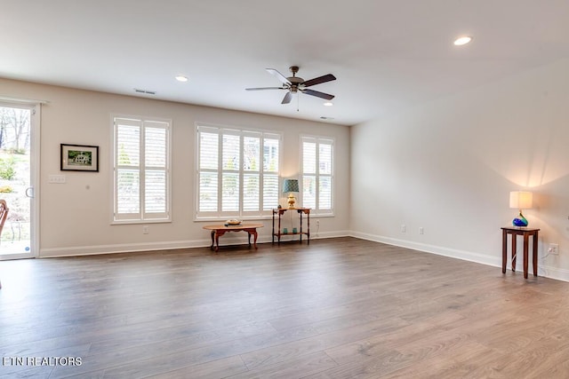 unfurnished room with a wealth of natural light, visible vents, recessed lighting, and wood finished floors