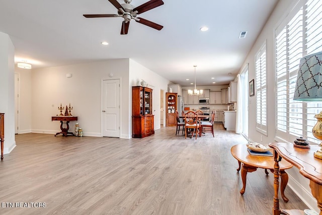 dining area with ceiling fan with notable chandelier, light wood-style flooring, recessed lighting, and baseboards