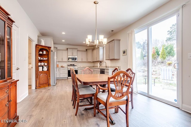 dining area with a wealth of natural light, a notable chandelier, recessed lighting, and light wood finished floors