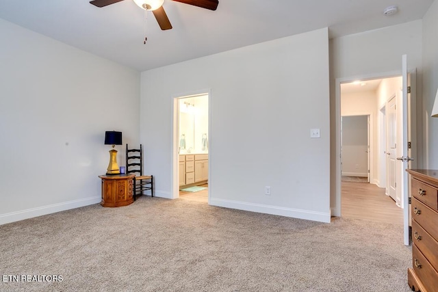 bedroom with ceiling fan, baseboards, light colored carpet, and ensuite bath