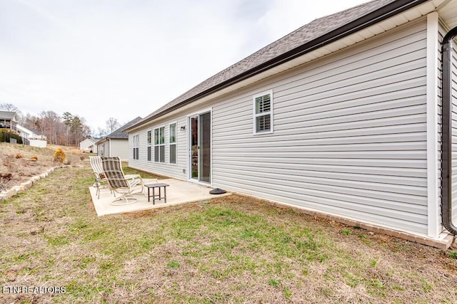 rear view of property featuring a lawn and a patio area