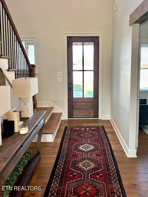 entrance foyer with stairs, wood finished floors, and a healthy amount of sunlight