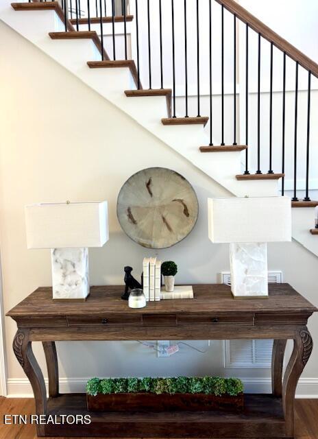 stairway with baseboards, plenty of natural light, and wood finished floors