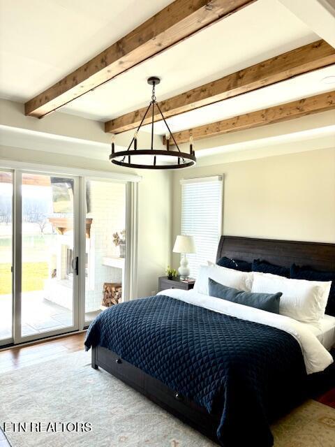 bedroom featuring beam ceiling, a chandelier, wood finished floors, and access to outside