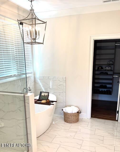 bathroom featuring a marble finish shower, visible vents, a freestanding bath, an inviting chandelier, and marble finish floor