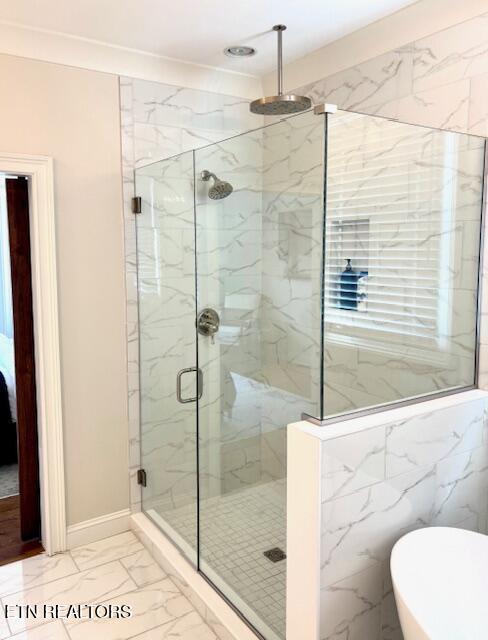 full bathroom with baseboards, marble finish floor, a marble finish shower, and a freestanding bath