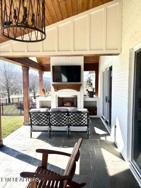 view of patio / terrace featuring an outdoor living space with a fireplace and fence