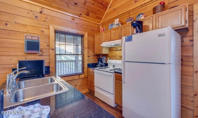 kitchen with wooden walls, under cabinet range hood, lofted ceiling, white appliances, and a sink