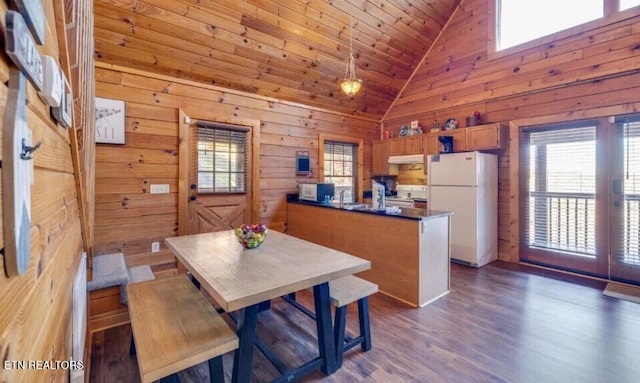 dining space with wood ceiling, dark wood-type flooring, a healthy amount of sunlight, and wood walls