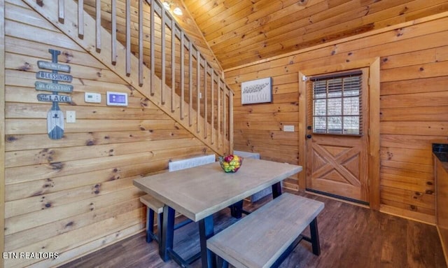 dining space with dark wood-style floors, wood walls, wooden ceiling, and vaulted ceiling