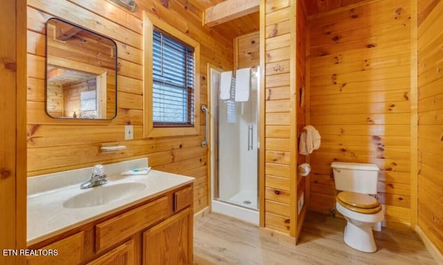 full bath with vanity, wood finished floors, a stall shower, wood walls, and toilet