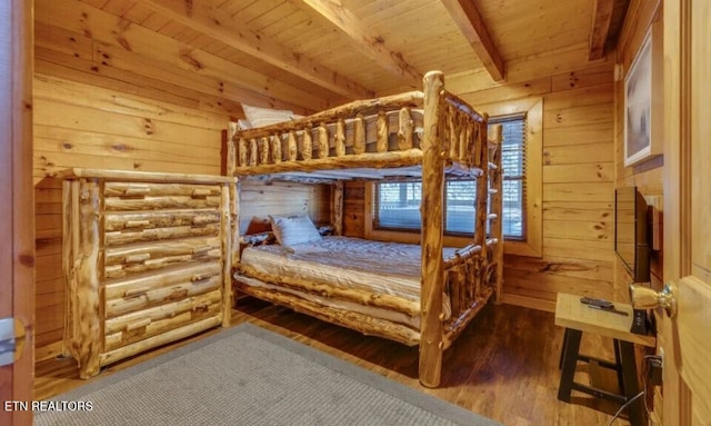 bedroom featuring wood finished floors, beam ceiling, wood walls, and wooden ceiling