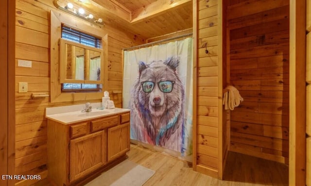 bathroom with curtained shower, wood finished floors, wooden walls, wood ceiling, and vanity