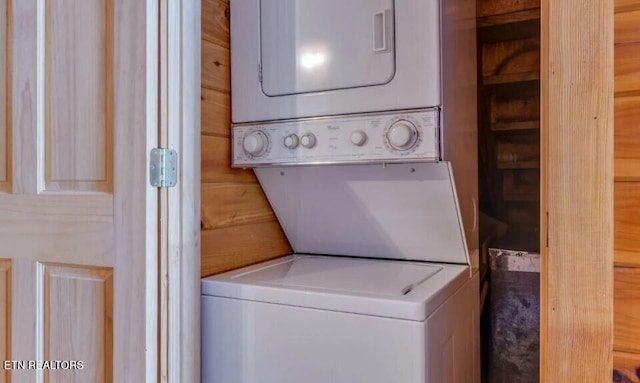 washroom featuring stacked washer and clothes dryer and laundry area