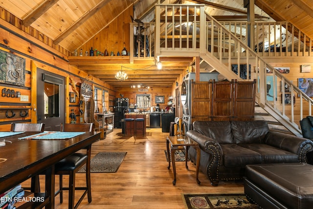 living area featuring stairs, wood walls, and a chandelier