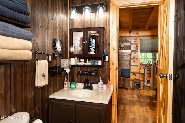 784 Wilderness Trl, Oneida, TN 37841 - half bath with wooden ceiling with exposed beams, wooden walls, vanity, wood finished floors, and toilet