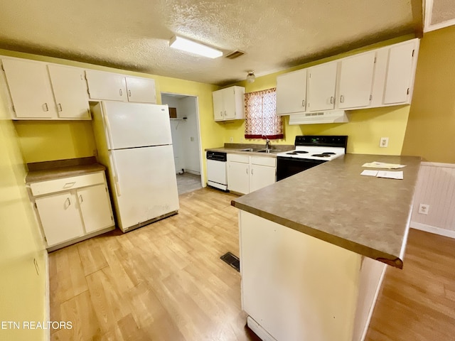 kitchen with under cabinet range hood, white appliances, light wood-style floors, a peninsula, and white cabinets