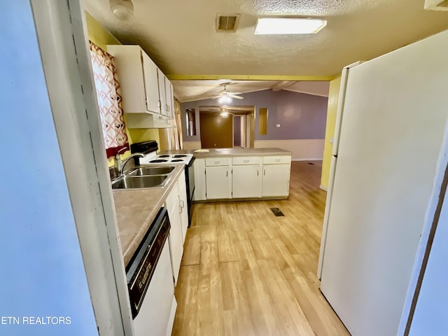 kitchen featuring white appliances, vaulted ceiling, white cabinets, a textured ceiling, and light wood-type flooring