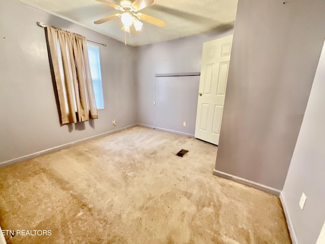 unfurnished bedroom with baseboards, carpet, and ceiling fan