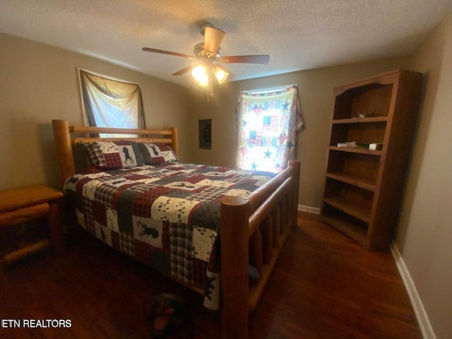 bedroom with ceiling fan, wood finished floors, baseboards, and a textured ceiling