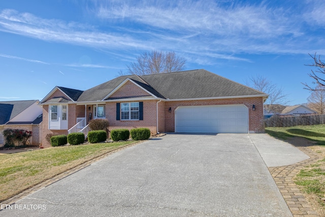 ranch-style home featuring an attached garage, fence, brick siding, and driveway