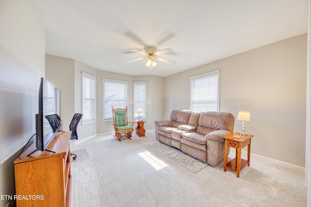 living room featuring baseboards, carpet, and ceiling fan