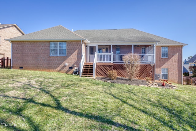 rear view of house with fence, roof with shingles, a yard, crawl space, and brick siding