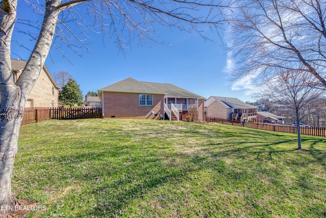 back of house featuring a yard, a fenced backyard, brick siding, and crawl space