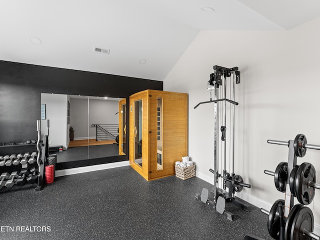 workout area with visible vents, baseboards, and vaulted ceiling